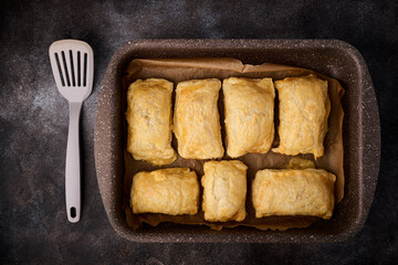 Tray with hot puff pastry patties with cheese, top view, close up
