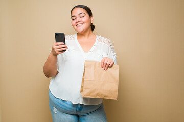 Happy fat young woman using a food delivery app on her phone