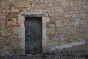 Fototapeta na wymiar Old door integrated on stone wall. Selective focus. Copy space.