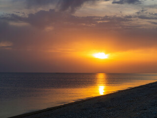 Tropical sea sunset. Beautiful view of the sunset in the sea, yellow and orange sky and waves in the seascape above the horizon in the ocean