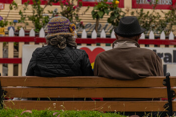 pareja de esposos amorosos tomando un descanso en una banca al aire libre