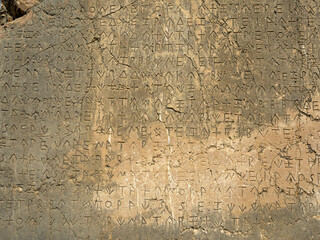 Ancient greek writing on stone wall of ancient city of Xanthos, Turkey