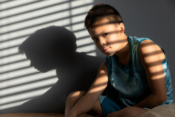 Obraz premium Lifestyle portrait of child sitting in the room at sunlight, childhood memories