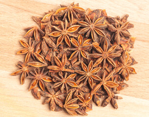 A group of star anises on a wooden background. Dried star anise spice fruits top view