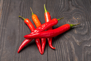 a pile of red chili peppers on a wooden background