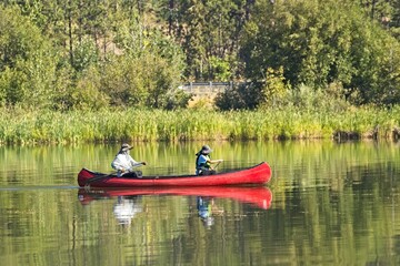 Fototapeta na wymiar Couple slowly paddles a canoe.