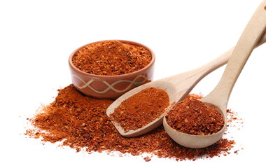 Spicy chili pepper flakes, crushed, milled dry paprika pile in clay pot isolated on white