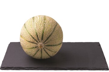 Close up view of Cantaloupe melon on black stone desk o  white background isolated. 