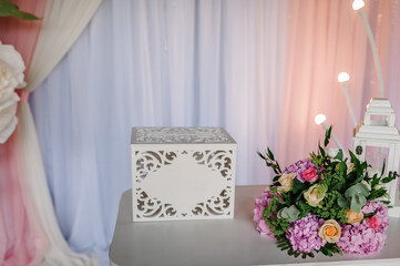 Vintage wedding gift box for money and greeting cards. Decoration flowers details on the table. Close up.