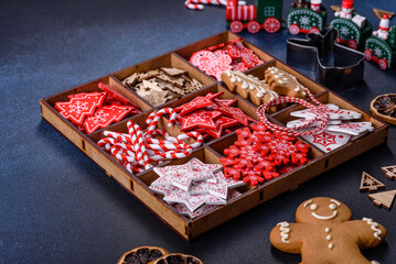 Christmas toys in white and red in a wooden sectional box against a dark concrete background