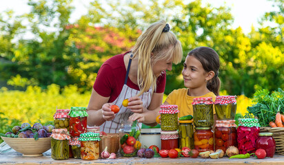 Woman with jar preserved vegetables for winter mother and daughter. Selective focus.