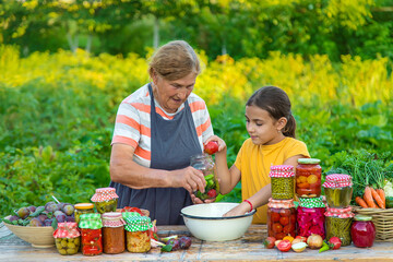 Women with jar preserved vegetables for the winter mother and daughter. Selective focus.