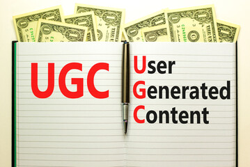 UGC user generated content symbol. Concept words UGC user generated content on white note on a beautiful background from dollar bills. Business and UGC user generated content concept. Copy space.