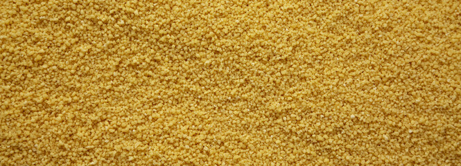 Raw organic couscous background, top view.