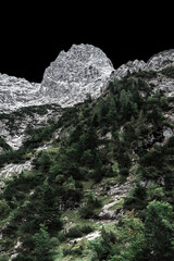 Bergspitze mit schwarzem Himmel von unten aus Höllentalklamm