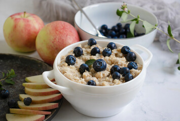 Oatmeal with fresh blueberries, apple, background