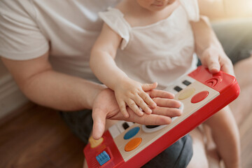 Obraz premium Close up of baby girl touch daddy's hand sitting in his arms