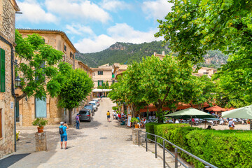 A picturesque street of shops and cafes in the medieval village of Valldemossa, Spain, on the Mediterranean island of Mallorca.	