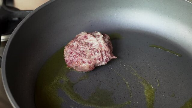 Placing the meatballs on the pan. Frying meatballs in hot oil on frying pan.
