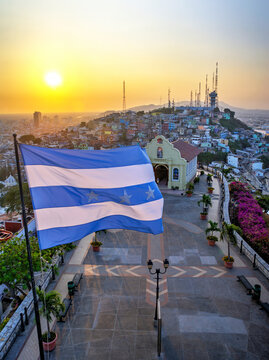 Guayaquil, Guayas, Ecuador - November, 2013: Vertical view from the lighthouse at the top of the Saint Ana hill, with a chapel and the Province's flag waving in the wind. Warm sunset. 