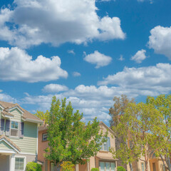 Fototapeta na wymiar Square White puffy clouds Row of traditional houses at Ladera Ranch in Southern California