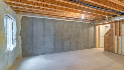 Panorama Unfinished basement with a plastic vapor barrier on the wall