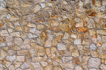Mauer mit Natursteinen im mediterranen Stil als dekoratives Element im Garten oder an der Fassade des Hauses