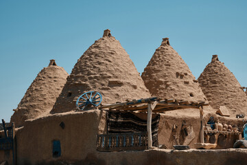 Fototapeta na wymiar Traditional mud brick or adobe made beehive houses. Harran, major ancient city in Upper Mesopotamia, nowadays is a district in Sanliurfa province, Turkiye. Roofs of beehive houses opposite clear sky