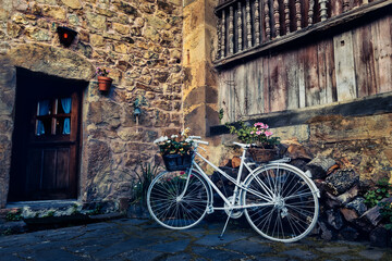 Bicycle with basket in fromt of old wall with flowers