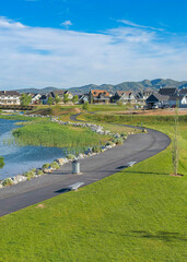 Fototapeta premium Vertical Whispy white clouds Panoramic view of a peaceful residential area at Daybreak, Utah