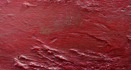 Rough uneven texture from a red wall.