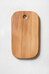 Wooden cutting board on white kitchen table top. Space for design. Top view, flat lay. Cooking concept with copy space.