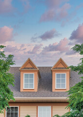 Vertical Puffy clouds at sunset Roof of a house with two gabled dormer windows at Utah