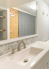 Vertical Interior of a bathroom with corner shower stall near the gray shower curtain
