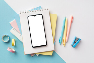 Back to school concept. Top view photo of school supplies smartphone over notebooks pens ruler...