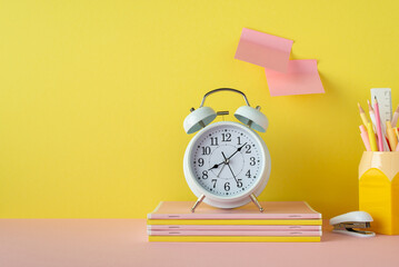 Back to school concept. Photo of school accessories on pink desk alarm clock stack of copybooks...