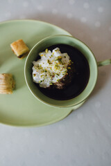 drinking chocolate in matching green cup and plate with assorted baklava desserts