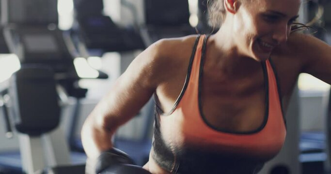 Fitness, Boxing And Sporty Woman Hitting A Punching Bag During An Intense Workout At The Gym. Powerful, Fit And Active Female Wearing Sports Gloves While Exercising And Training At A Health Club