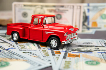 A toy car and a pile of money under it