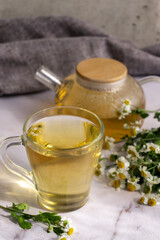 Chamomile tea. Herbal tea. Glass cup with warm fragrant chamomile tea
