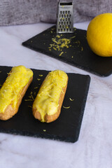 Eclair with custard and lemon glaze sprinkled with lemon zest.