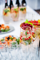 Stylish champagne glasses and food appetizers on table at wedding reception