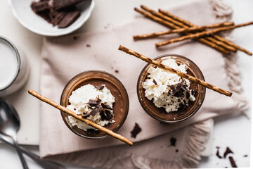 chocolate cake with coffee 
chocolate mousse cream in a glass cup on a white background with whipped cream and salty sticks snack snack sweet dessert