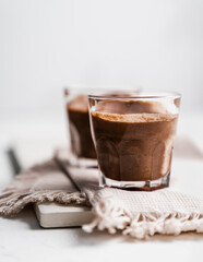 chocolate cake with coffee 
chocolate mousse cream in a glass cup on a white background with whipped cream and salty sticks snack snack sweet dessert