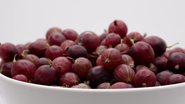 Gooseberry Fruit On A White Plate. Close Up. Fresh Red Gooseberries Spin On White Background. 60 FPS, 4k, ProRes