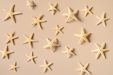 Starfishes on beige background as sand. Top view. Concept summer beach vacation.
