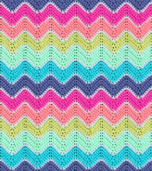 Seamless knitted pattern in the form of zigzags is crocheted with multi-colored threads. Acrylic...