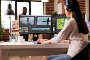 Creative digital editor editing movie footage at home, using professional effects software. Content...