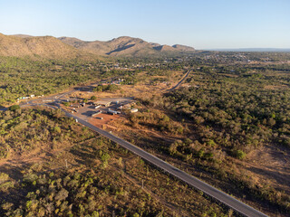 beautiful and extensive flat road through the undergrowth of the Brazilian savannah with beautiful mountains on the horizon