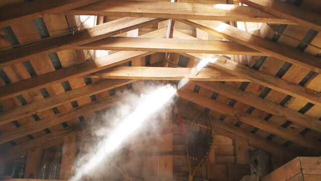 Sugar shack house with wood fire pan and iron kettle evaporator concentrating and evaporating steam at ceiling roof for production of maple syrup in Highland country, Virginia